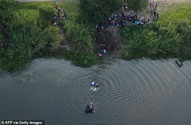 في هذه الصورة الجوية التي تم التقاطها في 11 مايو 2023 ، يدفع الناس عوامة مع المهاجرين عبر نهر ريو غراندي إلى الولايات المتحدة من المكسيك ، في براونزفيل ، تكساس.