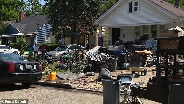 يمكن رؤية صناديق قمامة وأجزاء من السياج وكابلات وصناديق قمامة تغطي فناء منزله الأمامي في هذه الصورة
