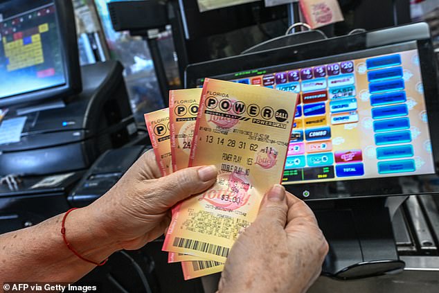 امرأة تحمل تذاكر يانصيب Powerball داخل متجر في Homestead ، فلوريدا يوم الأربعاء