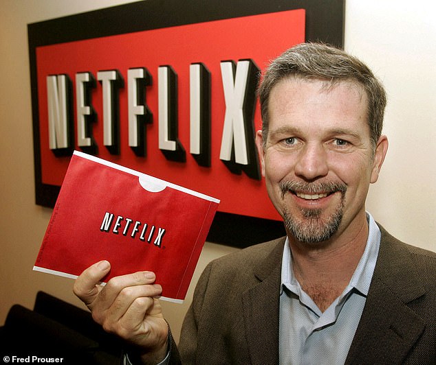 ريد هاستينغز، مؤسس Netflix، يحمل أحد المظاريف التي تستخدمها Netflix لشحن أقراص DVD إلى الأعضاء في مكتبه في بيفرلي هيلز، كاليفورنيا