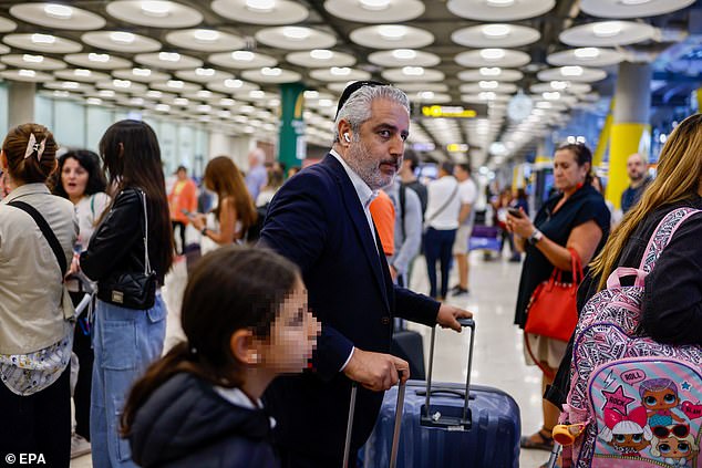 ويسارع الإسرائيليون للهروب إلى المطارات في جميع أنحاء العالم.  (في الصورة: الركاب الذين فروا من الدولة المحاصرة يصلون إلى مطار باراخاس في مدريد، إسبانيا، يوم الاثنين)