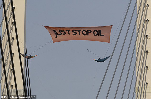 معبر دارتفورد: نشطاء من منظمة Just Stop Oil يرفعون لافتة فوق جسر الملكة إليزابيث الثانية المهجور فوق نهر التايمز في دارتفورد في 17 أكتوبر من العام الماضي