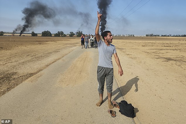 فلسطينيون يسيرون بعيدًا عن كيبوتز كفار عزة، إسرائيل، بالقرب من السياج مع قطاع غزة في 7 أكتوبر في صورة التقطتها إسلايا.