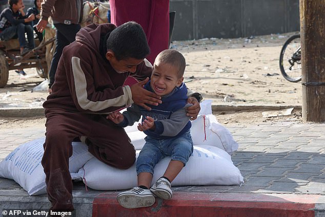 فلسطينيون يتسلمون أكياس الطحين في مركز توزيع وكالة الأمم المتحدة لإغاثة وتشغيل اللاجئين الفلسطينيين في مخيم رفح للاجئين في قطاع غزة في 21 تشرين الثاني/نوفمبر