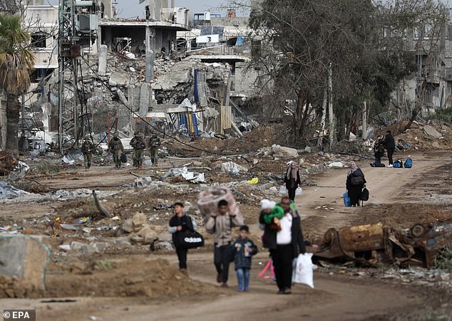 فلسطينيون يسيرون بعد العبور من شمال قطاع غزة إلى جنوب قطاع غزة بينما يتحرك الجنود الإسرائيليون على طول طريق صلاح الدين في وسط قطاع غزة، 28 نوفمبر 2023