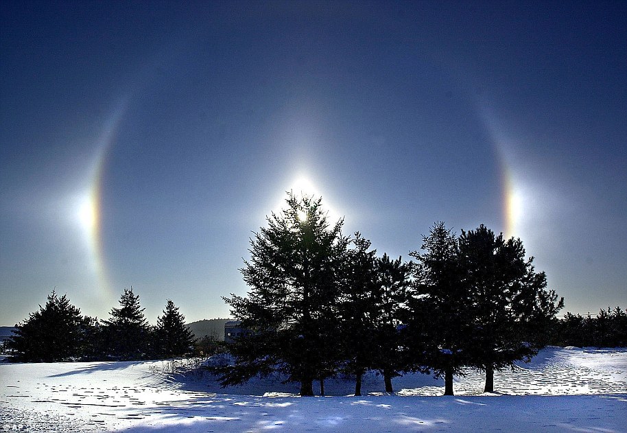 يتم رؤية Sundogs أو parhelia فوق حقل مغطى بالثلوج في دولوث.  تظهر شموس الشمس، المعروفة أيضًا باسم الشموس الوهمية بسبب البقع المضيئة على جانبي الشمس، عندما ينكسر ضوء الشمس بالقرب من الأفق بواسطة بلورات الجليد في الغلاف الجوي