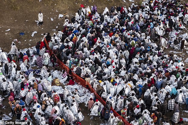 في هذه الصورة الجوية، يحاول المهاجرون، الذين يرتدي العديد منهم بطانيات مايلر التي قدمتها حرس الحدود الأمريكية، البقاء دافئين بعد قضاء الليل خارج مركز معالجة بجوار الحدود بين الولايات المتحدة والمكسيك يوم الاثنين