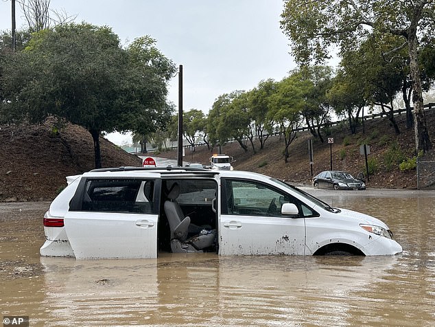 سيارة مغمورة بمياه الفيضانات بالقرب من جسر علوي مع هطول الأمطار