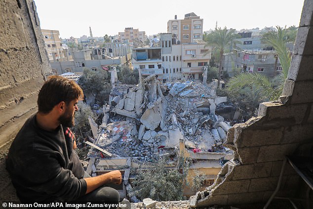 فلسطينيون يتجمعون حول أنقاض المباني المدمرة جراء القصف الإسرائيلي على دير البلح وسط قطاع غزة عشية عيد الميلاد