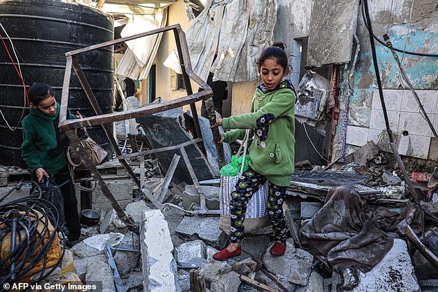 فتيات فلسطينيات يبحثن بين أنقاض مبنى بعد القصف الإسرائيلي في رفح جنوب قطاع غزة، في 26 ديسمبر 2023