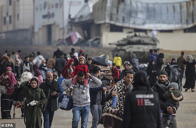 فلسطينيون نازحون داخليًا يعبرون الدبابات الإسرائيلية بعد أن طلب الجيش الإسرائيلي من سكان مخيم خان يونس مغادرة منازلهم والتوجه نحو مخيمات رفح بالقرب من الحدود المصرية، في جنوب قطاع غزة، في 27 يناير/كانون الثاني.