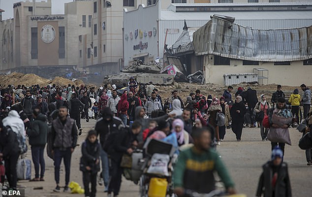 فلسطينيون نازحون داخليًا يعبرون الدبابات الإسرائيلية بعد أن طلب الجيش الإسرائيلي من سكان مخيم خان يونس مغادرة منازلهم والتوجه نحو مخيمات رفح بالقرب من الحدود المصرية، في جنوب قطاع غزة، في 27 يناير/كانون الثاني.