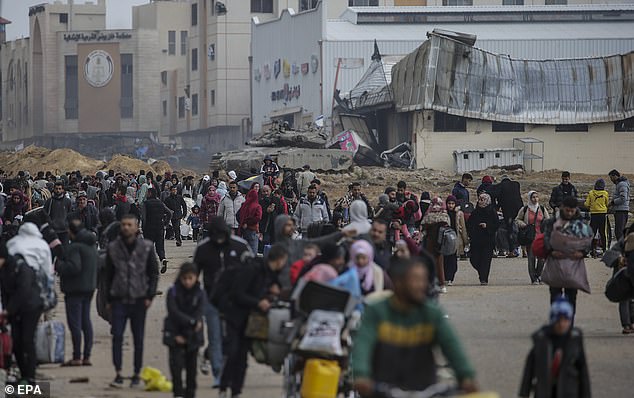 فلسطينيون نازحون داخليًا يعبرون الدبابات الإسرائيلية بعد أن طلب الجيش الإسرائيلي من سكان مخيم خان يونس مغادرة منازلهم والتوجه نحو مخيمات رفح القريبة من الحدود المصرية