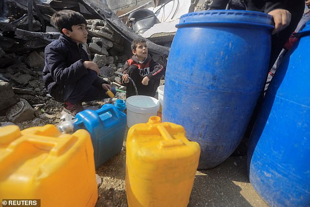 فلسطينيون يتجمعون لجمع المياه من منزل دمرته غارة إسرائيلية في مخيم جباليا للاجئين في شمال قطاع غزة في 7 فبراير/شباط.