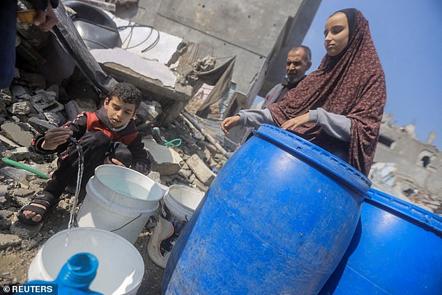 فلسطينيون يتجمعون لجمع المياه من منزل دمرته غارة إسرائيلية، وسط الصراع المستمر بين إسرائيل وحركة حماس الإسلامية الفلسطينية، في مخيم جباليا للاجئين في شمال قطاع غزة في 7 فبراير.