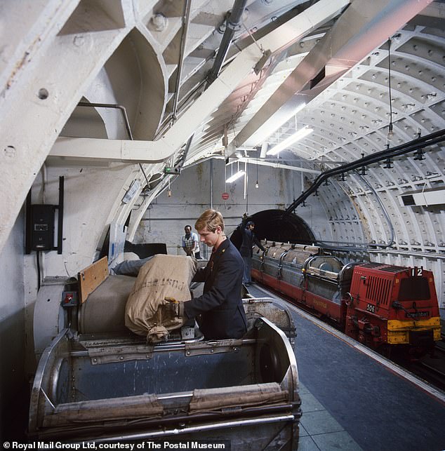1969: عامل يقوم بتحميل أكياس البريد في حاوية متجهة إلى قطار Mail Rail