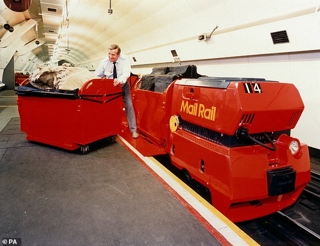 عامل يقوم بتفريغ عمود من Mail Rail في عام 1987. تم إغلاق النظام في عام 2003 بعد أن أعلن أنه غير اقتصادي