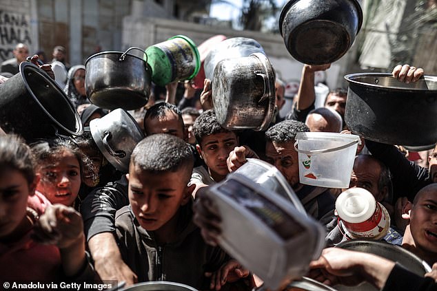 الشعب الفلسطيني ذو الأواني الفارغة يحصل على الطعام الذي توزعه الجمعيات الخيرية.  وتواجه غزة أزمة جوع مع تفاقم الوضع، وسط حصار بسبب الهجوم الإسرائيلي المستمر