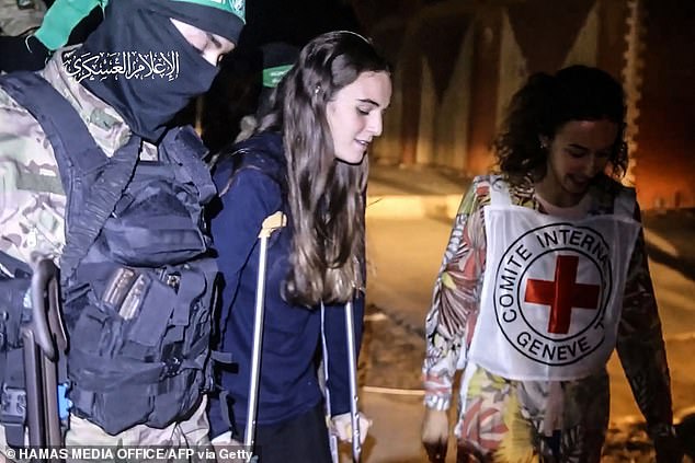 صورة مأخوذة من مقطع فيديو نشره المكتب الإعلامي لحماس تظهر مقاتلا من حماس ومسعفا من الصليب الأحمر يرافقان الرهينة الإسرائيلية المفرج عنها حديثا مايا ريغيف إلى مركبة تابعة للصليب الأحمر، في قطاع غزة في وقت مبكر من يوم 26 نوفمبر 2023.