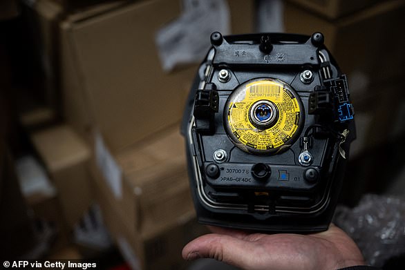 ميكانيكي يحتفظ بوحدة الوسادة الهوائية التي صنعتها الشركة المصنعة للوسائد الهوائية اليابانية Takata